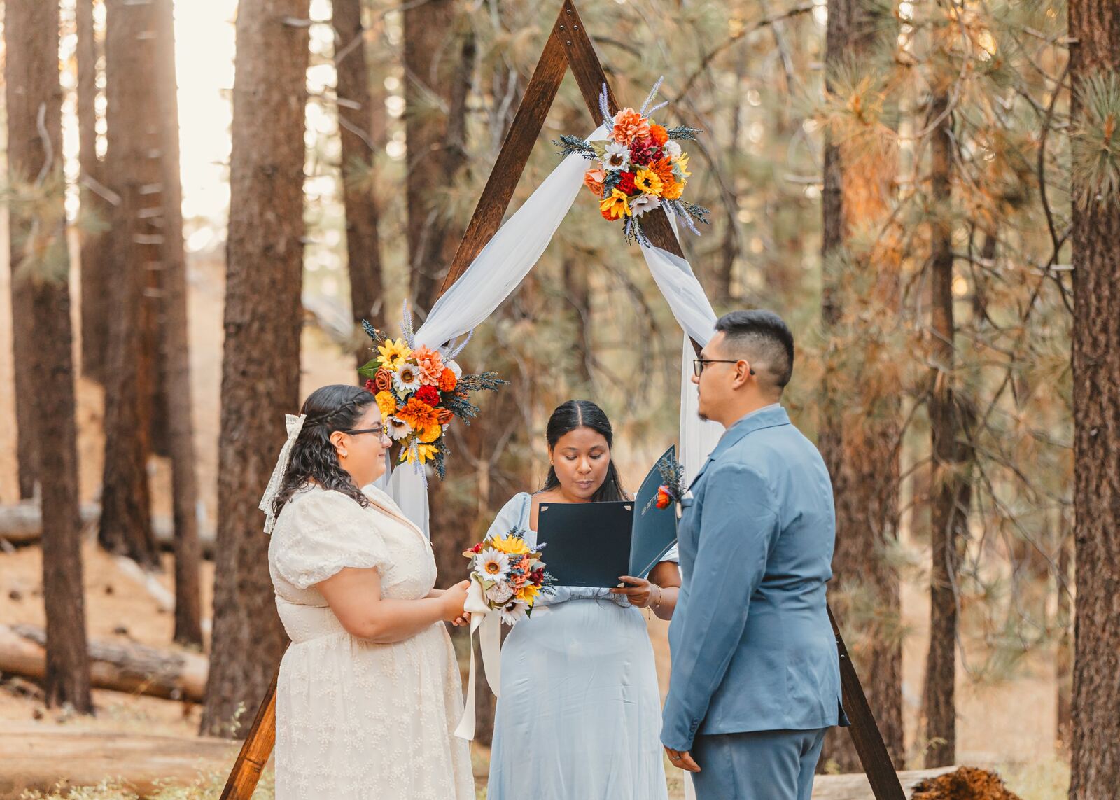 Andria Thomas officiating between Estella and Derek during their ceremony
